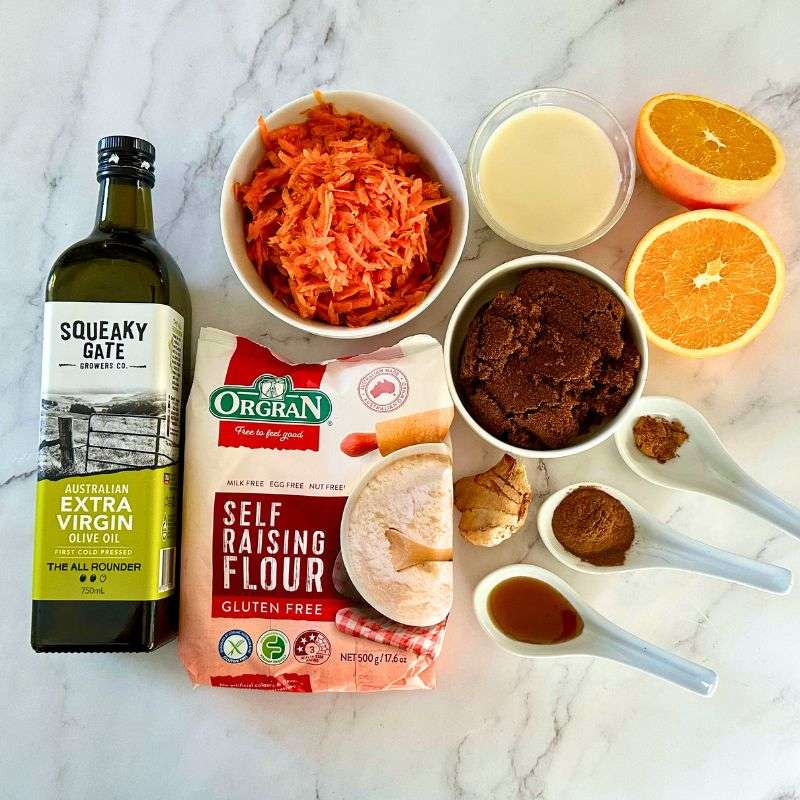 nut and gluten free carrot cake ingredients including olive oil, gluten free flour, carrot, oranges, oat milk and spices