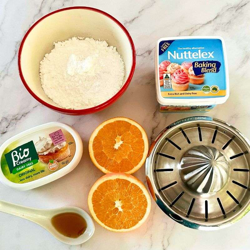 dairy free cream cheese and orange frosting ingredients with citrus juicer