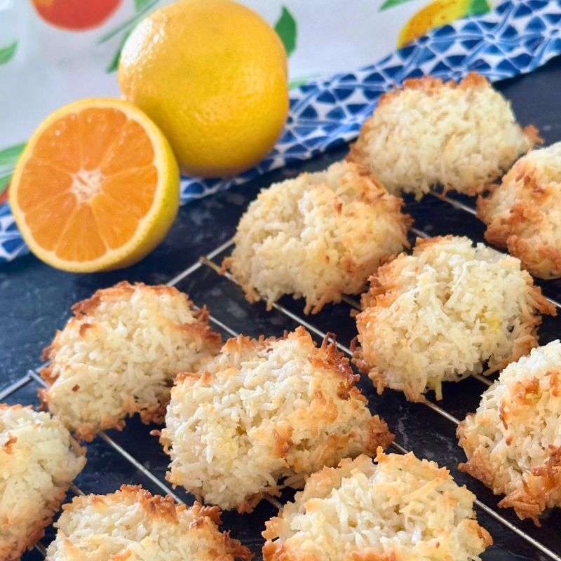 vegan orange coconut macaroons on wire rack with fresh orange