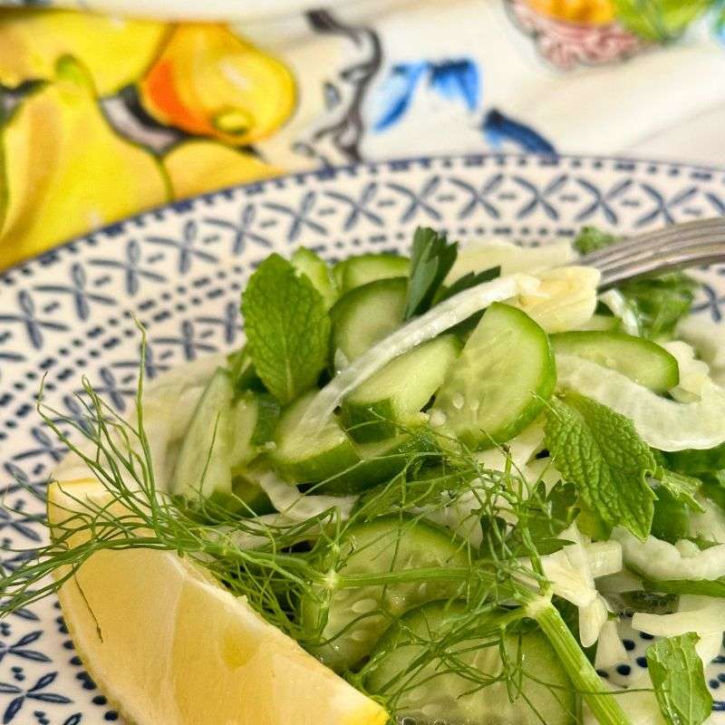 lemon fennel and cucumber salad on blue and white plate